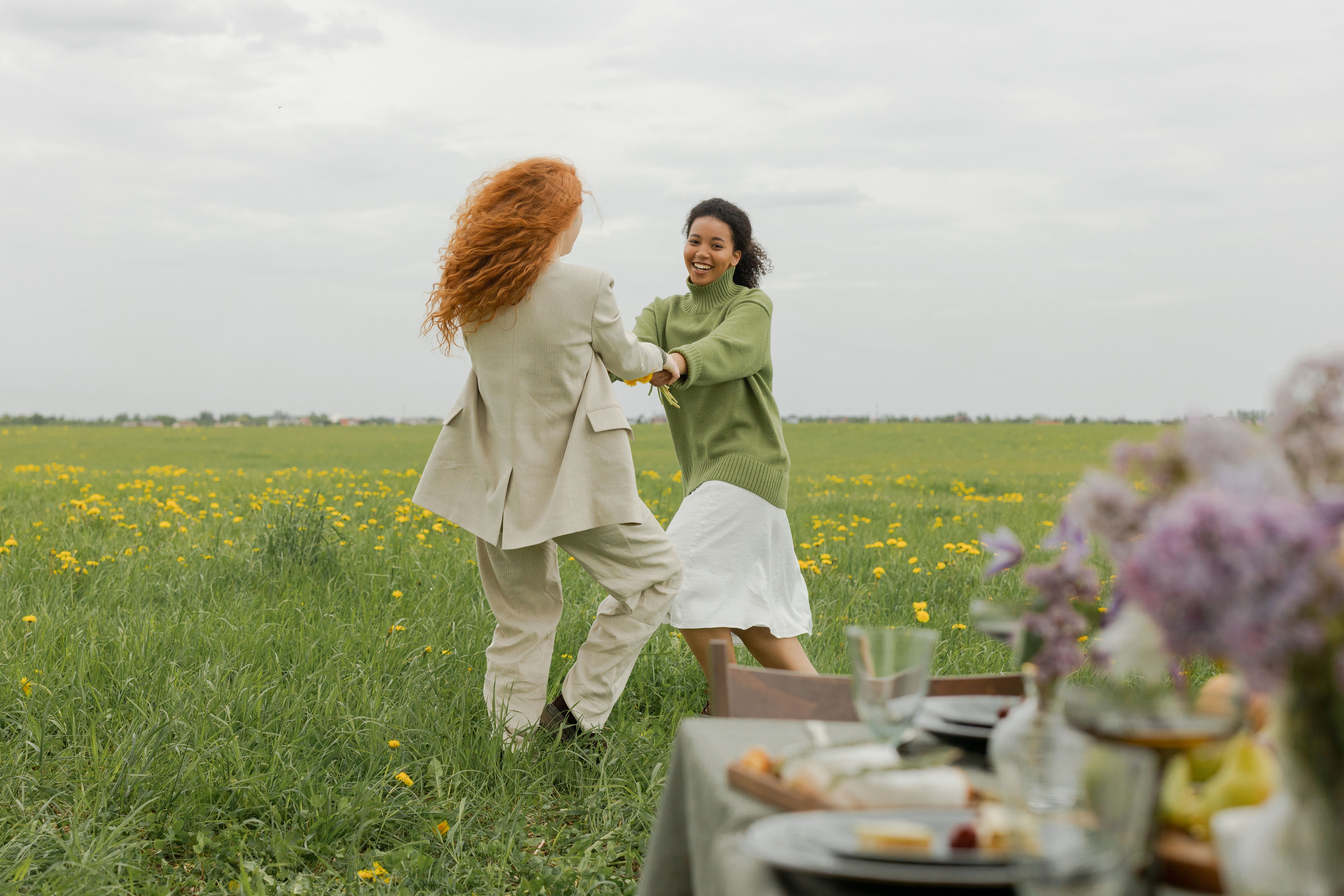 Women Holding Hands while in a Flower Field · Free Stock Photo