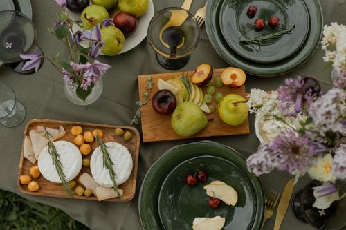 Free Elegant table setting with fresh fruits, cheese, and floral decor creating a rustic and inviting ambiance. Stock Photo