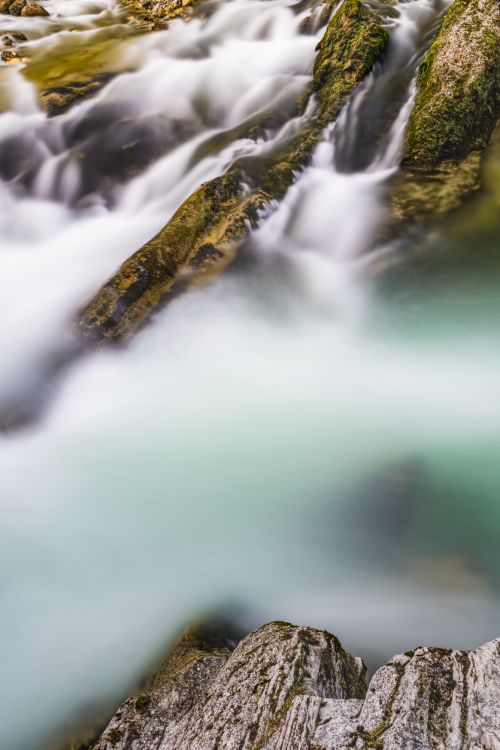 Free Captured in a long exposure, this serene stream flows over mossy rocks outdoors, creating a tranquil scene. Stock Photo