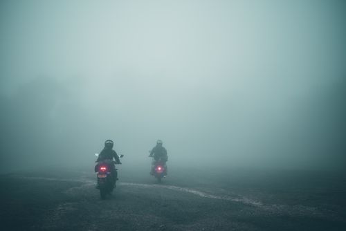 Free Two motorcyclists ride through dense fog on a road in Soacha, Colombia. Stock Photo