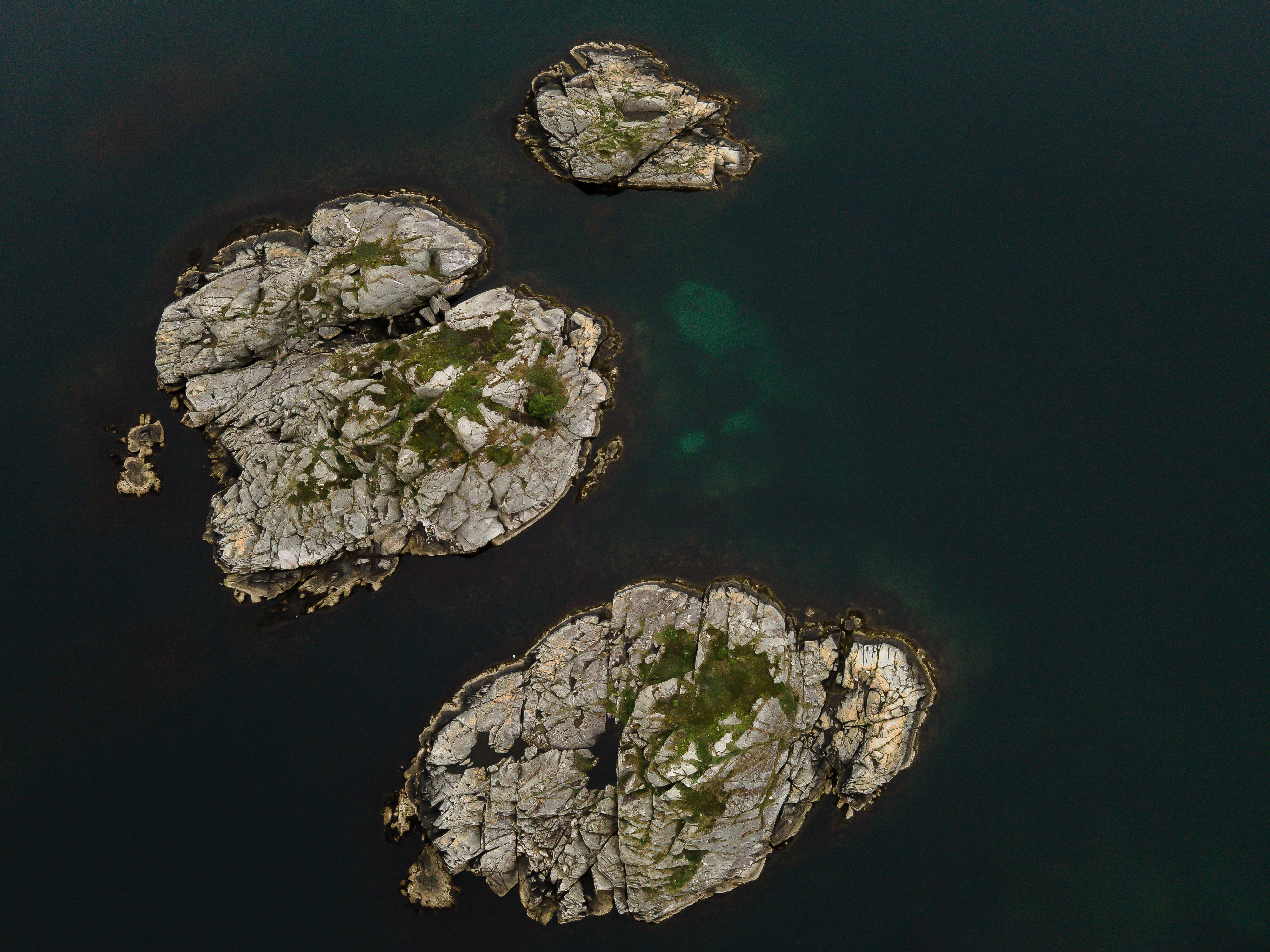 A stunning aerial shot of rocky islets in Veavågen, Norway showcasing natural geological formations.