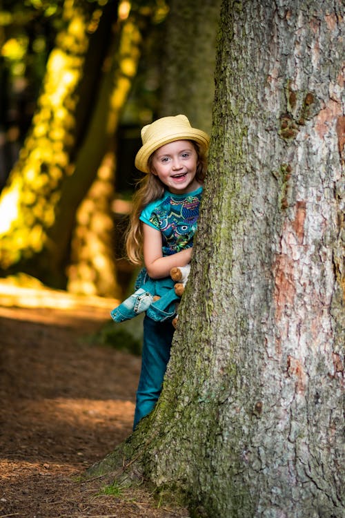 Adorable Girl hiding behind a Tree