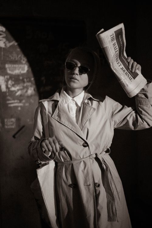 Free A fashionable woman in sunglasses holding a newspaper, exuding a vintage vibe. Stock Photo
