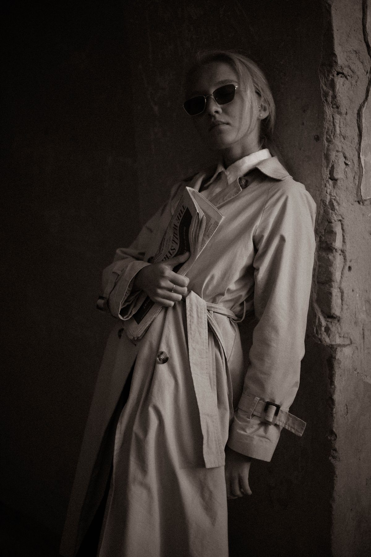 A woman in a grey coat with sunglasses — the modern technical trench