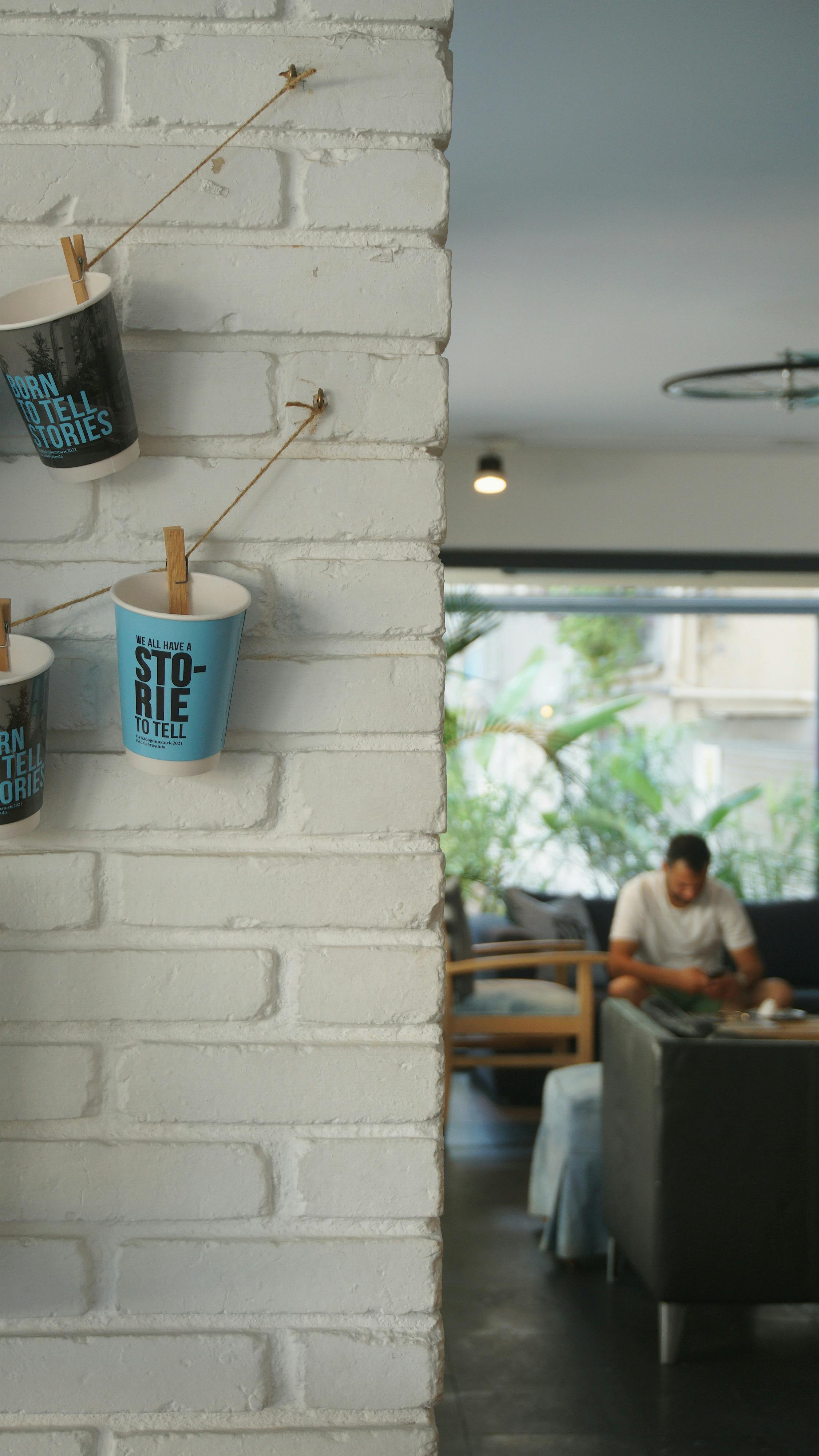 Hanging Paper Cups on White Wall · Free Stock Photo