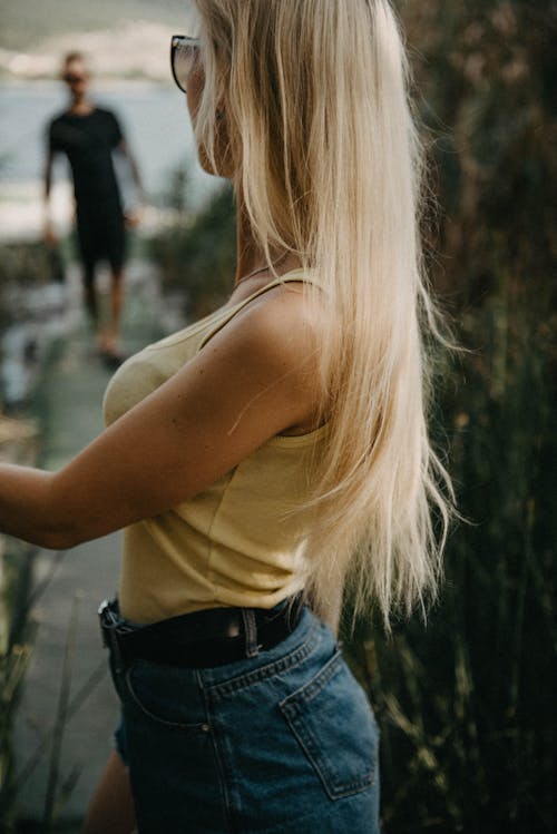 A Woman in Yellow Tank Top and Denim Shorts