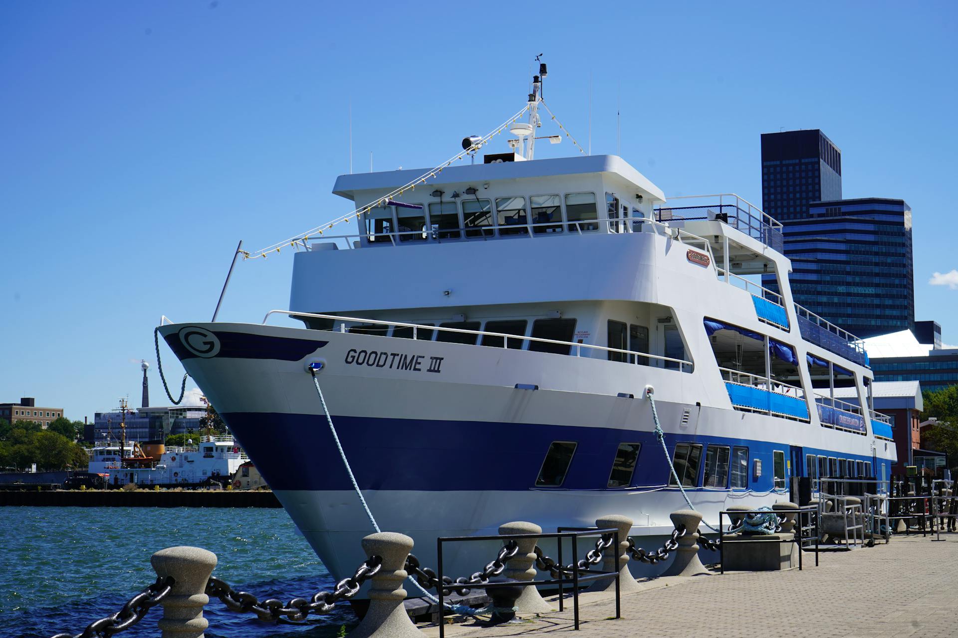 Large cruise ship "Goodtime III" docked at urban waterfront on a sunny day.