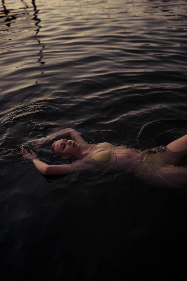 Woman In Bikini Floating On Water