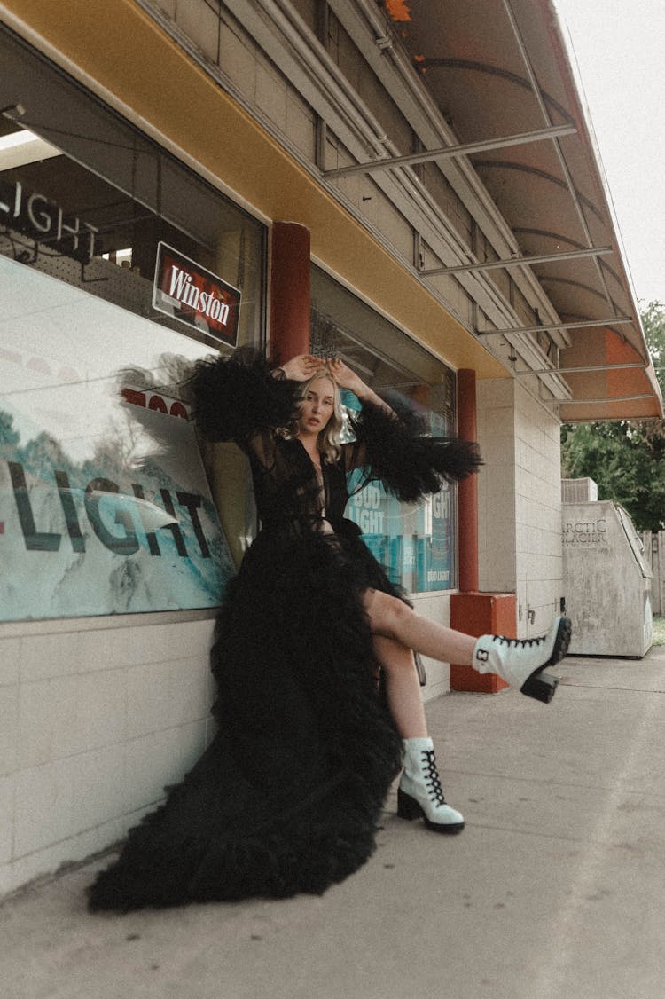 Woman In A Dress Leaning On A Store Window