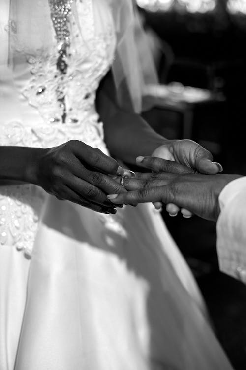 Grayscale Photo of Bride Putting the Wedding Ring on Her Groom