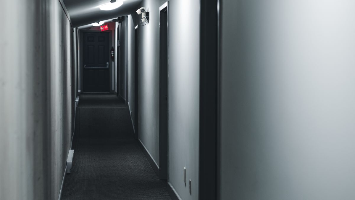 Couloir d'immeuble faiblement éclairé avec des portes d'appartement fermées