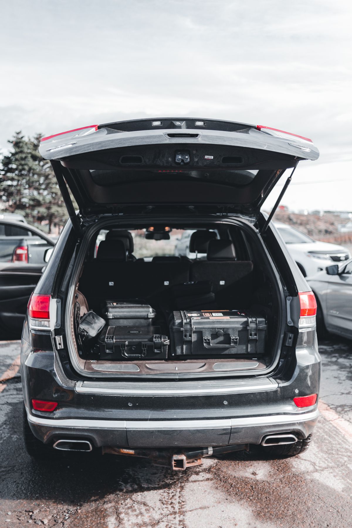 Open vehicle cargo area with organized hard cases and gear for a packing plan