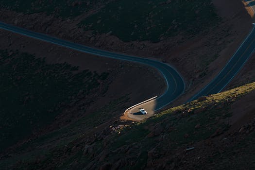 Aerial view of a car racing on a winding mountain road at Pikes Peak in Colorado.