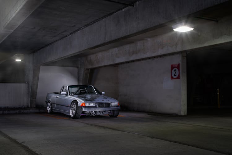 A Modified Gray Car Parked In A Building Parking Lot