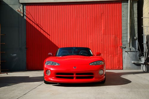 Red Luxury Car Parked Near Garage with Red Wall