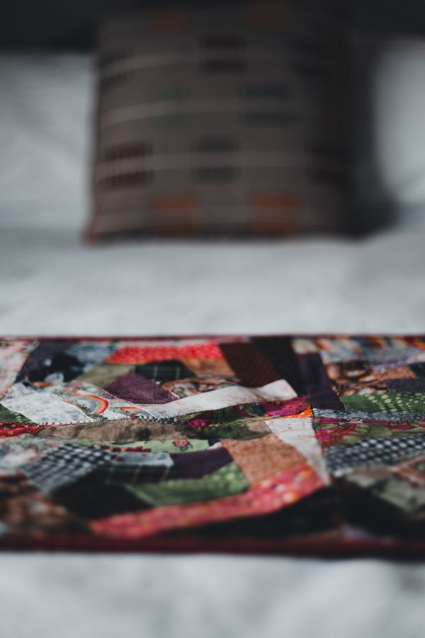 Colorful patchwork quilt block pieces being sewn by hand, beginner quilting class project