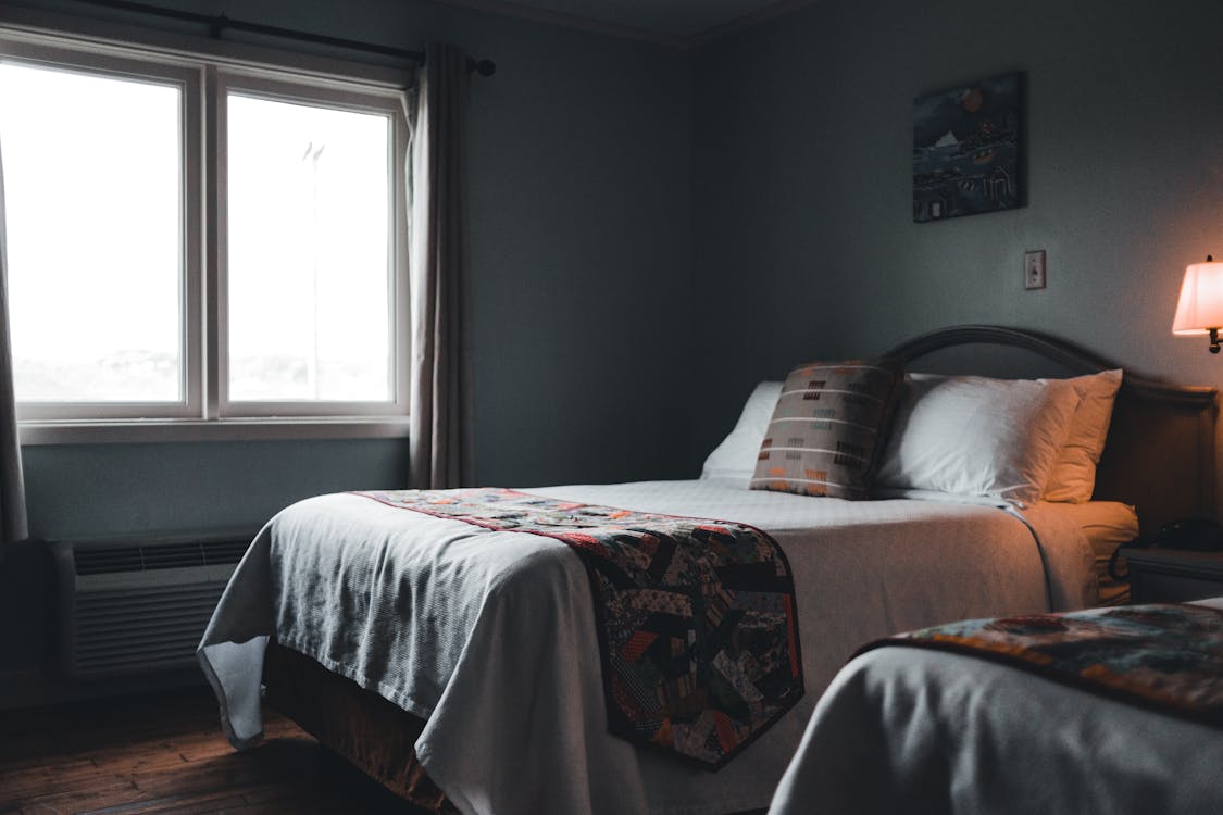 Free A Bed with Pillows Near the Glass Window Stock Photo