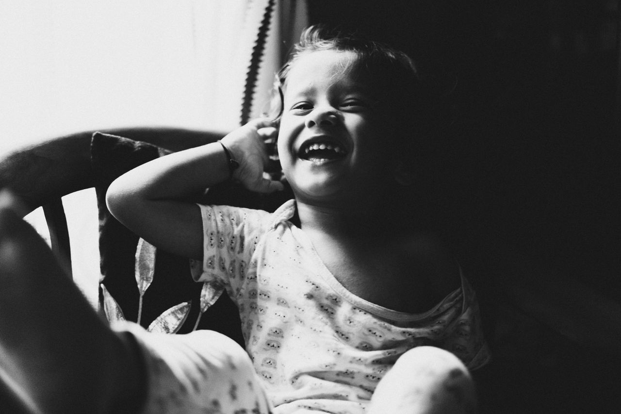 smiling child in black and white capturing carefree joy near a sunny w