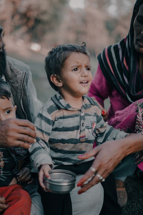 Free A touching scene depicting family bonding and shared experiences outdoors. A young boy sits with family members. Stock Photo