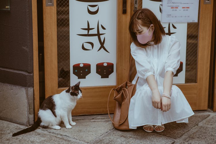 Woman In Mask Looking At Cat