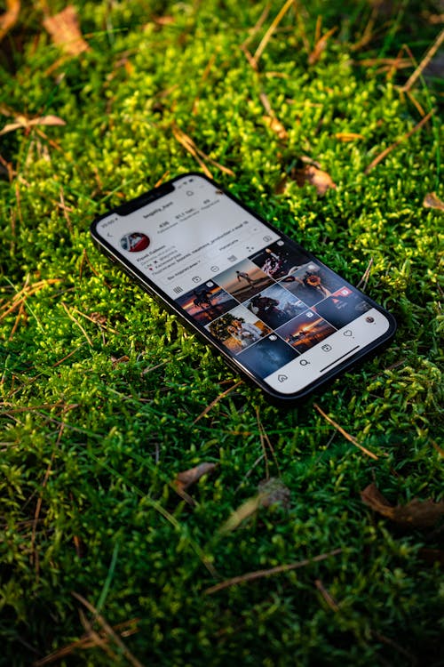 Free Close-Up Shot of Black Mobile Phone on Green Grass Stock Photo