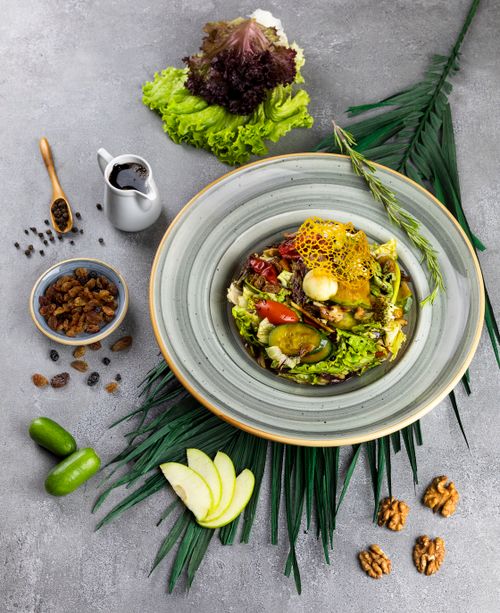 Free A meticulously arranged gourmet salad with fresh vegetables and a delicate honeycomb garnish. Stock Photo