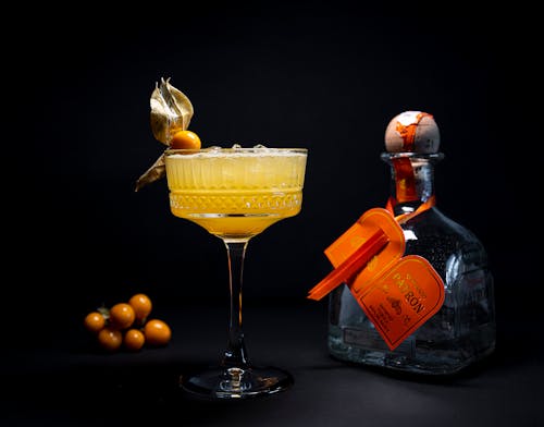 Free Cocktail in a Glass by a Bottle of Alcohol Stock Photo