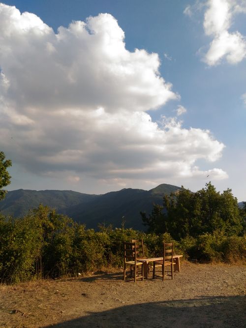 Free Rustic chairs on a mountainside overlook under a cloudy summer sky. Stock Photo