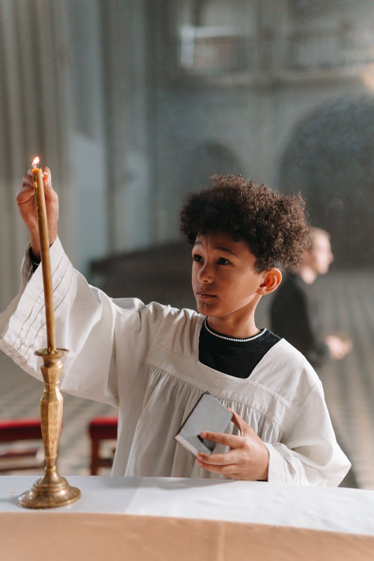 Curly Haired Boy Lighting A Candle 