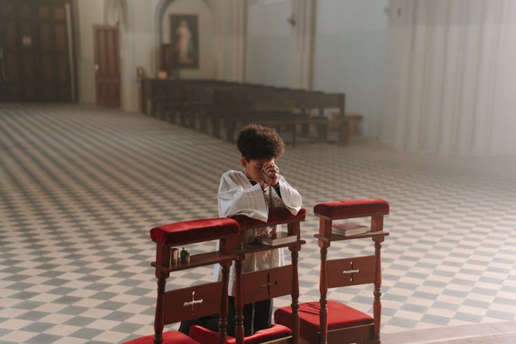 A Boy Praying In A Church