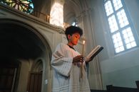 Woman in White and Brown Robe Holding Book