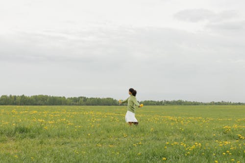 Boy in White Shirt and Yellow Shorts Running on Green Grass Field
