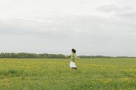 Boy in White Shirt and Yellow Shorts Running on Green Grass Field