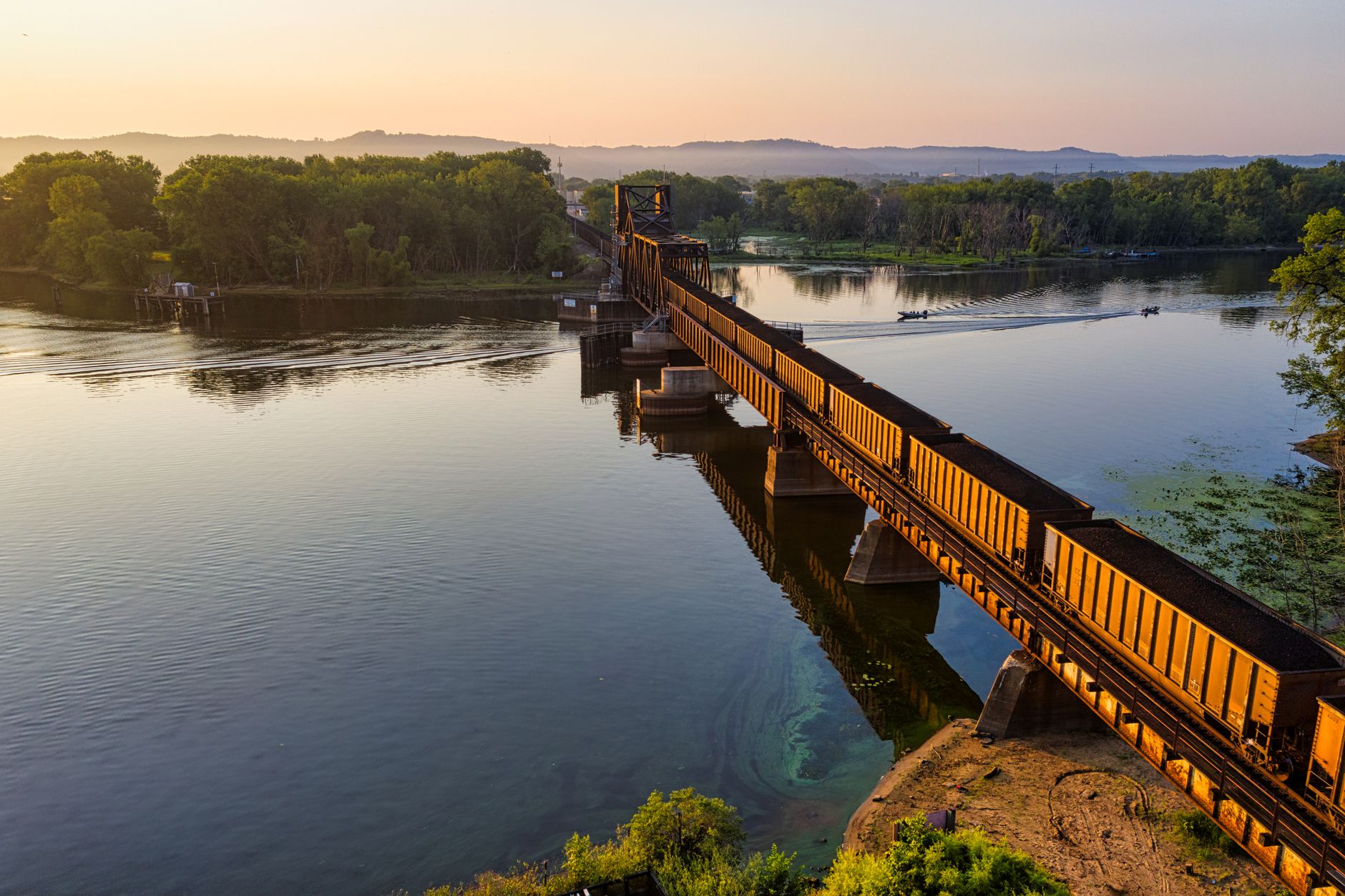 Stunning aerial view of a train crossing a river bridge at sunset in La Crosse, Wisconsin.