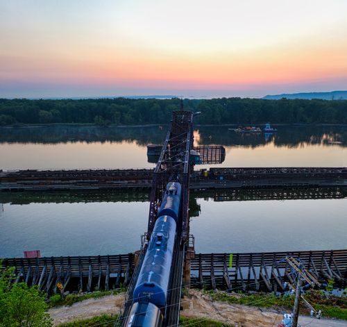 Free Aerial shot of a train crossing a swing bridge over a river at sunrise in La Crescent, MN. Stock Photo