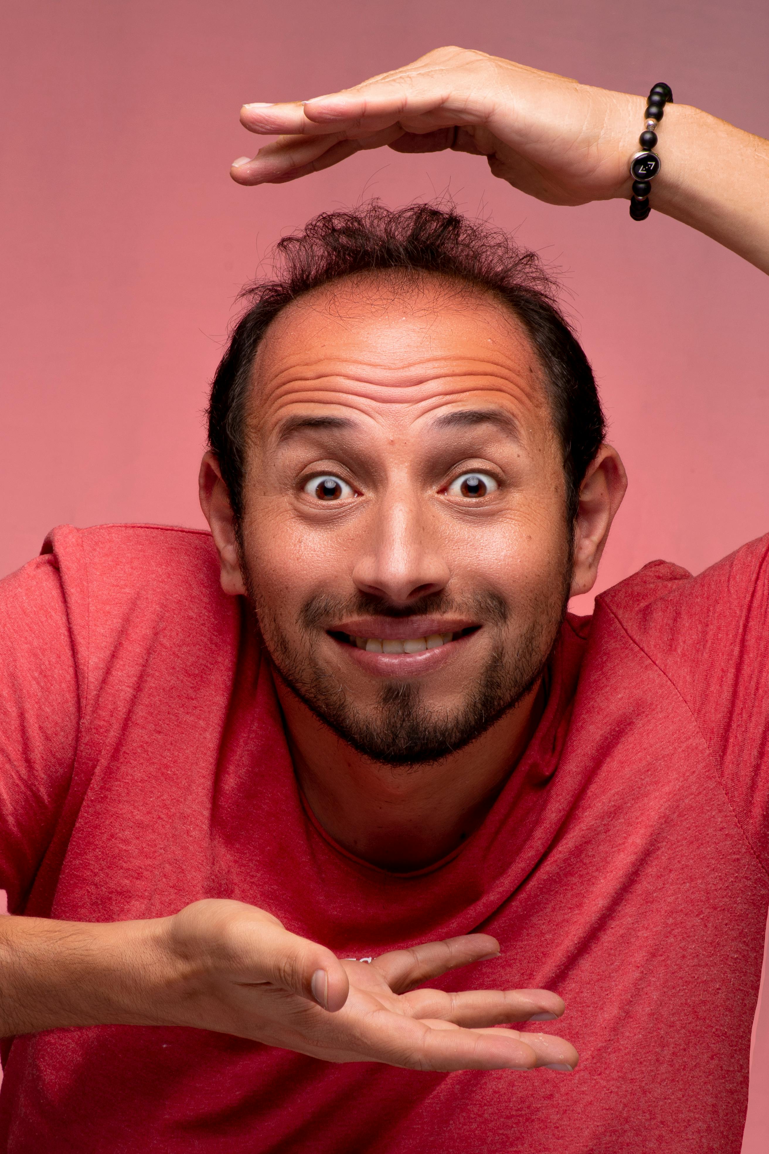 Portrait of a man making a funny, expressive face in a studio setting.