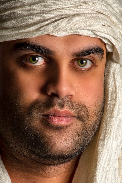 A Close-up Shot of a Man with White Headscarf