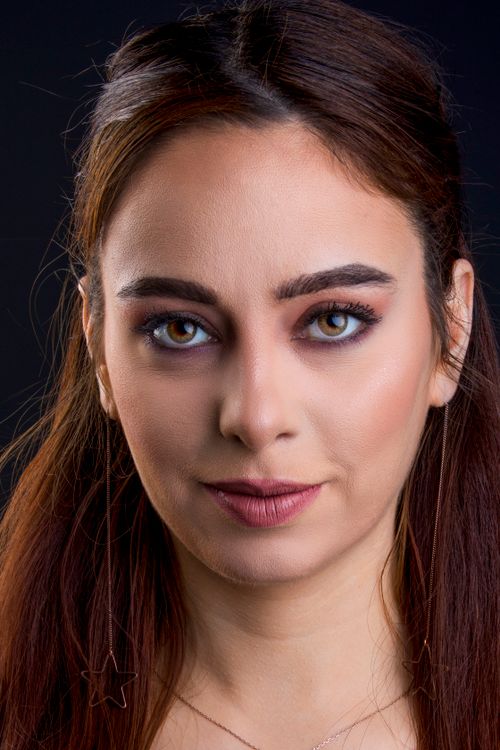 Free Close-up portrait of a young woman with stunning eye makeup, looking confidently at the camera. Stock Photo