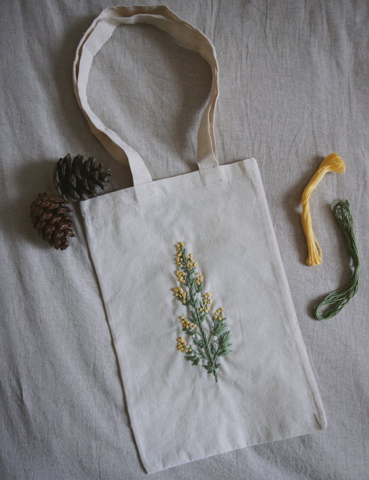 A Cotton Tote Bag With Flowers And Leaves Design