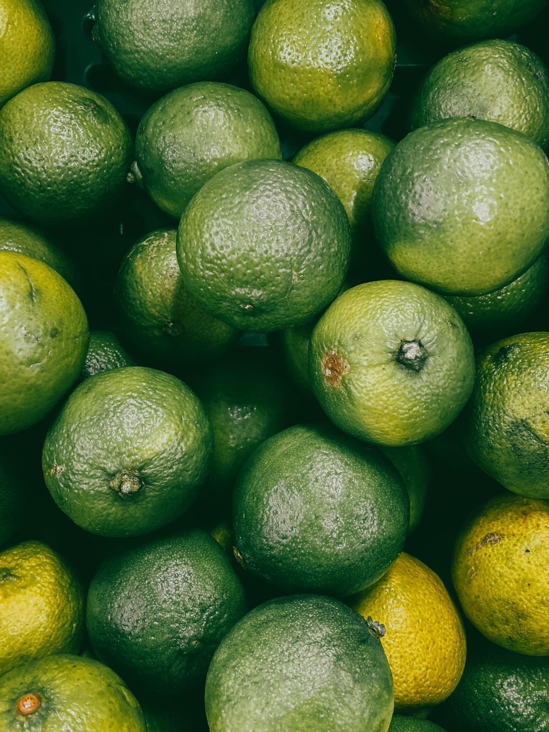 Green Lemon Fruit on White Surface · Free Stock Photo
