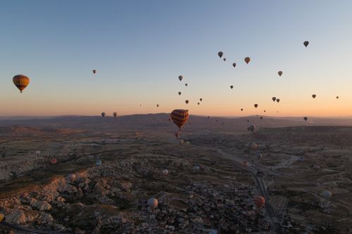 Free Hot air balloons soar over Cappadocia, Turkey, at sunrise, creating a picturesque landscape. Stock Photo
