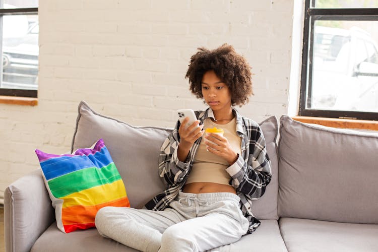 Woman Seated On Couch Using Phone 