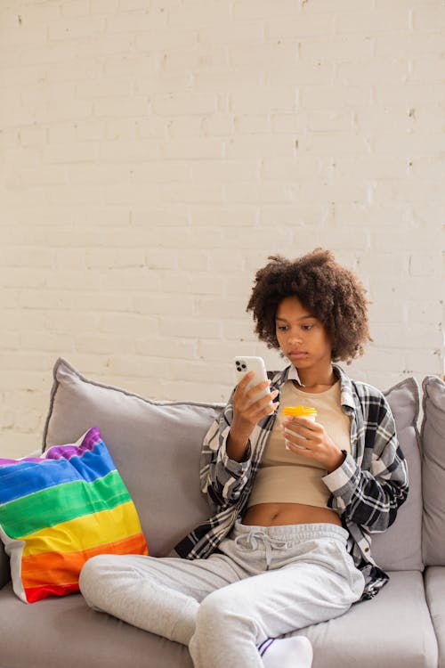 Free Woman sitting on Couch using Phone  Stock Photo