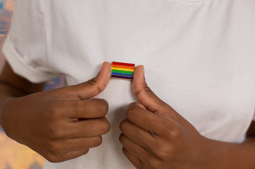 Close-up Photo of Pride Pin on White Shirt