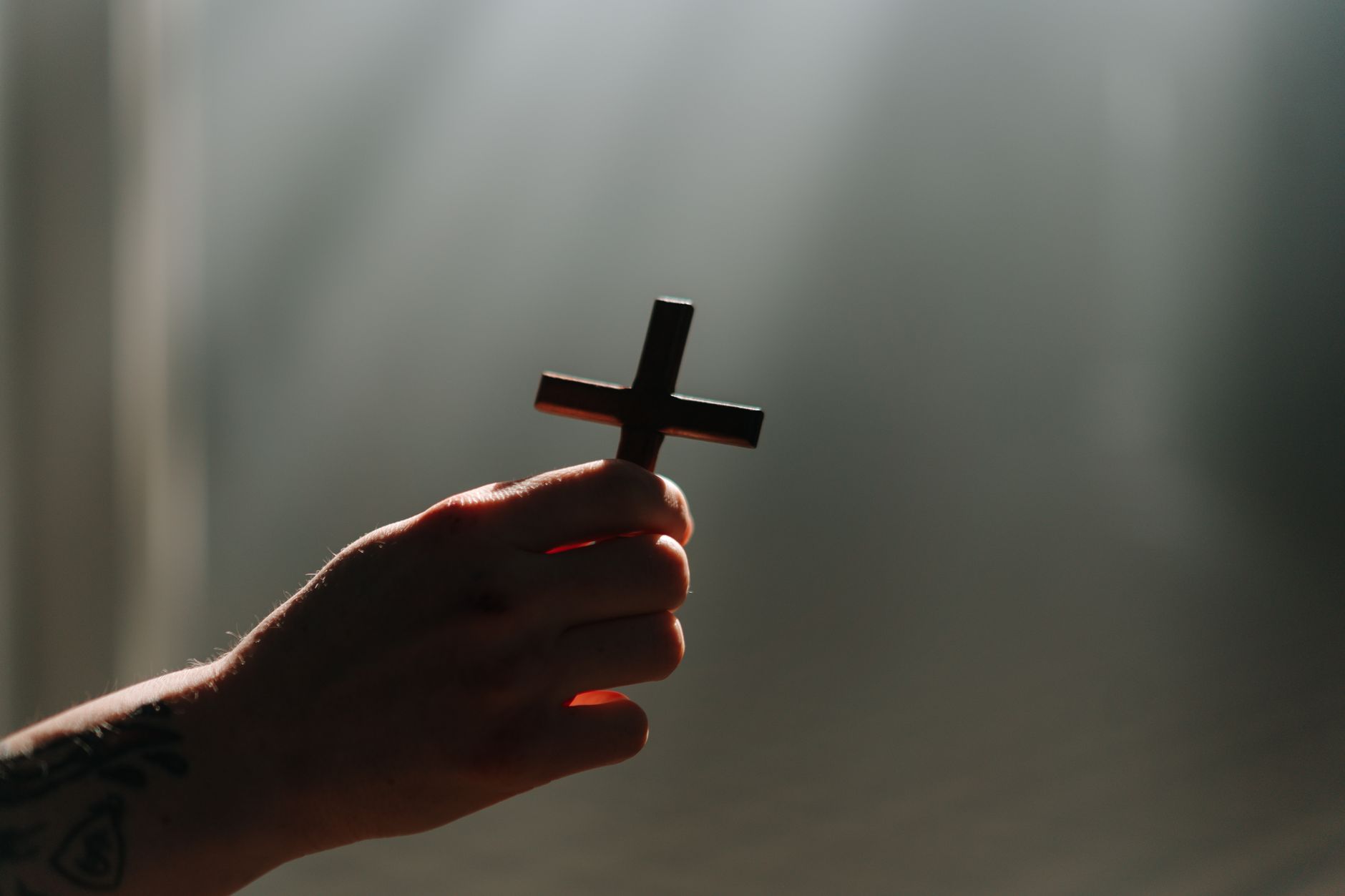 Christian hope represented by a hand holding a cross in soft light.