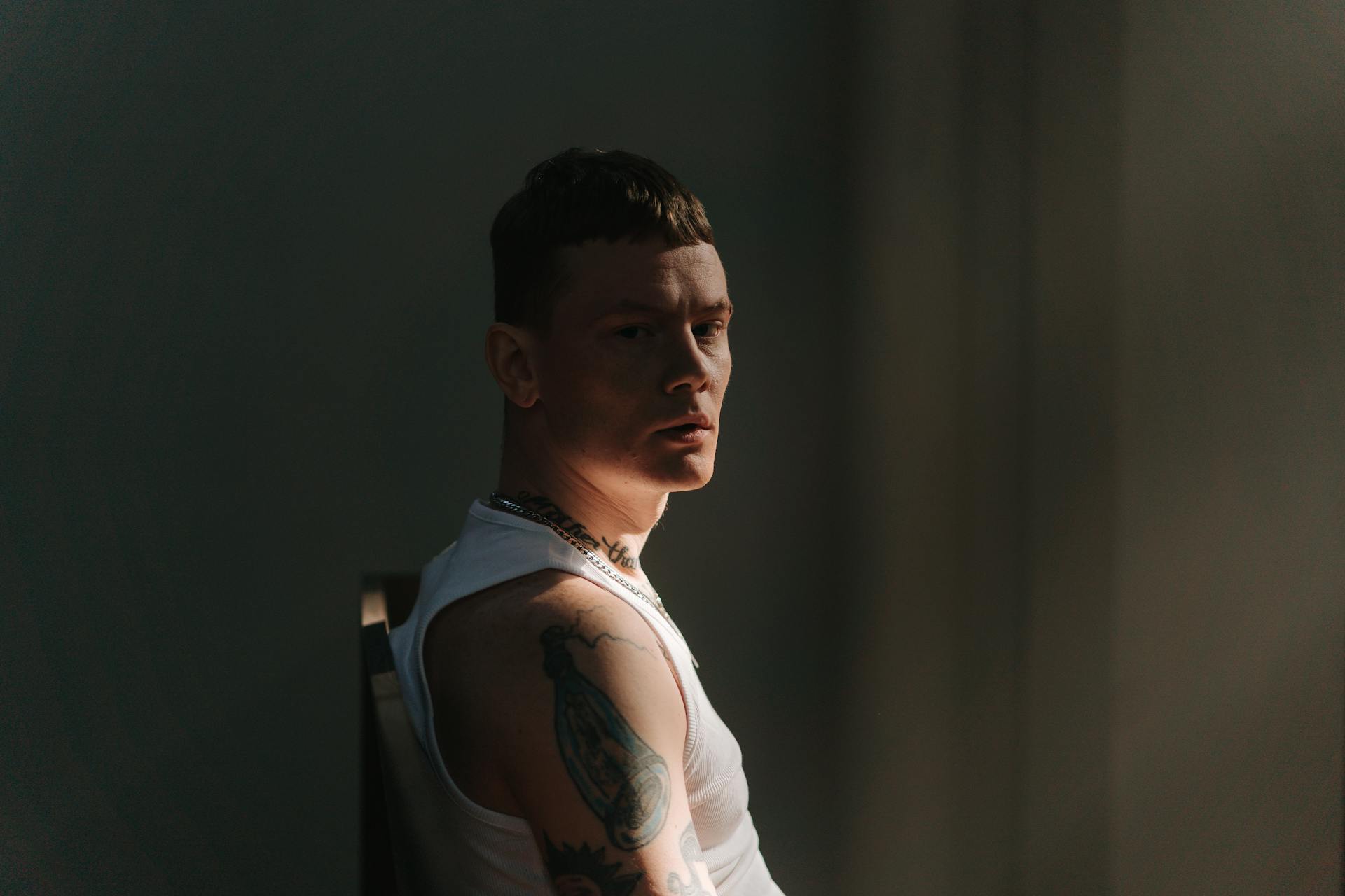A Man in White Tank Top Looking Over Shoulder