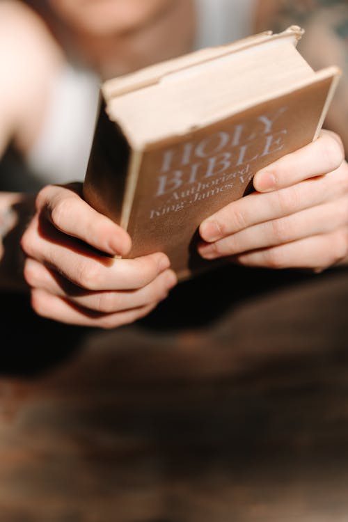 Close-Up Shot of a Person Holding a Bible