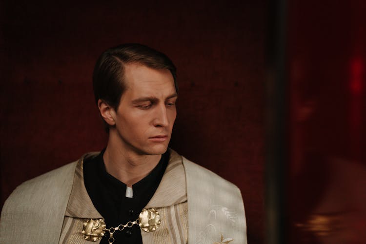 A Male Priest In A Confessional