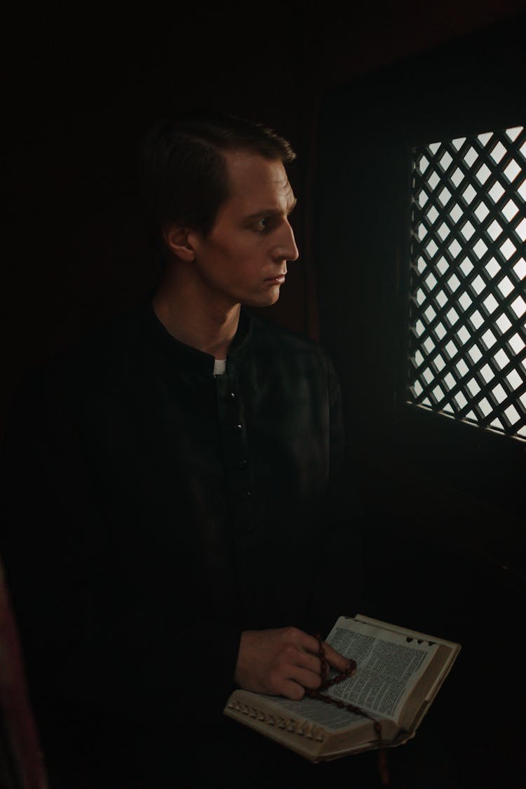 A Priest Sitting Inside The Confession Room