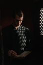 A Priest Reading a Bible in the Dark